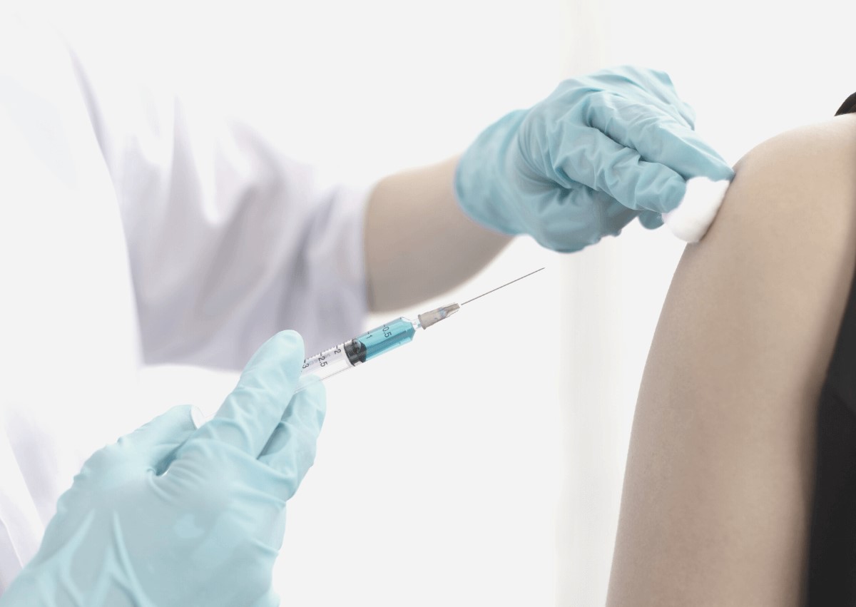 Hoitaja pistää rokotteen potilaan käsivarteen.